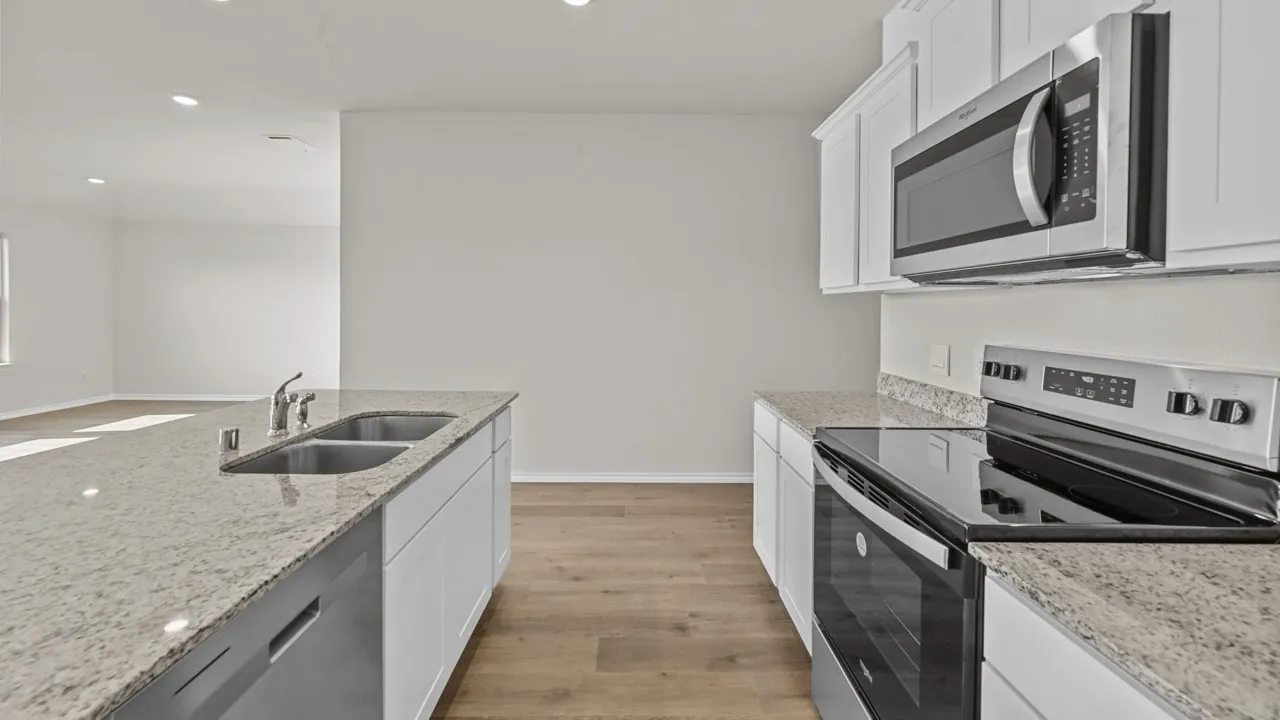 Kitchen featuring light-toned countertops, white cabinetry, and stainless steel appliances
