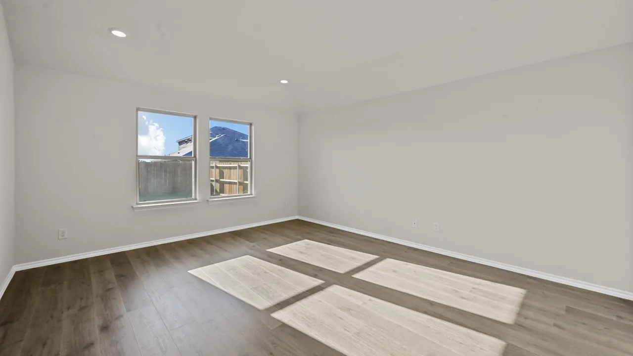 Spacious room featuring wood-finish flooring, two large windows, recessed lighting, and a neutral wall palette