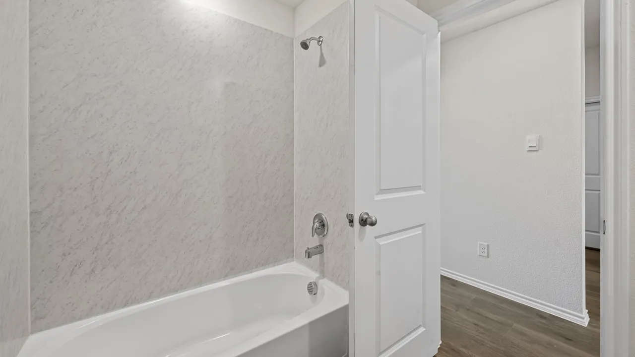 Bathtub shower combination with textured surround and chrome fixtures