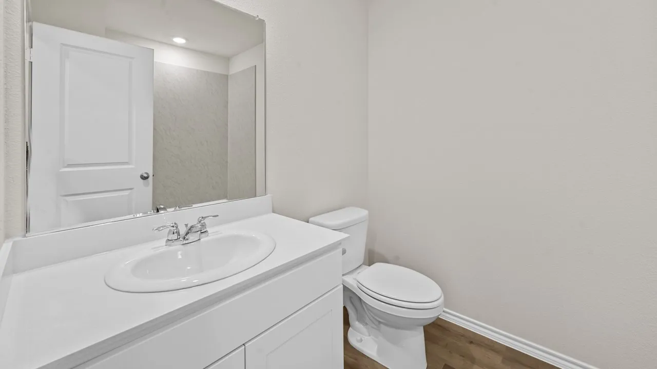 Bathroom featuring a single vanity with an integrated sink, chrome faucet, and white cabinetry