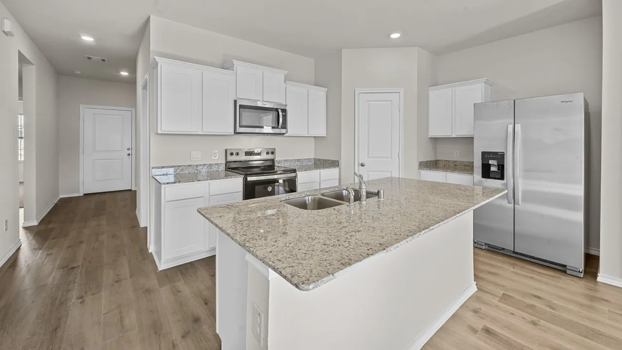 Kitchen featuring a central island with a double basin sink and stainless steel faucet