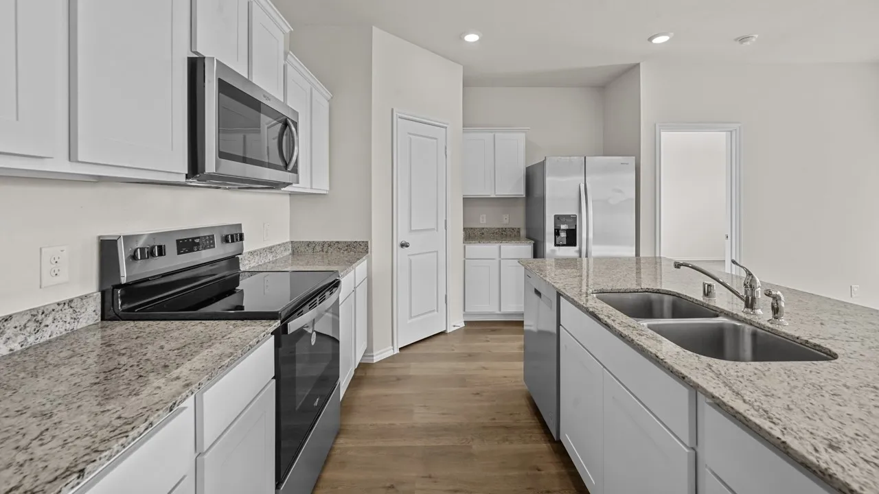 Kitchen featuring an island with a double basin stainless steel sink, granite countertops, white cabinetry, stainless steel appliances, and wood-finish flooring