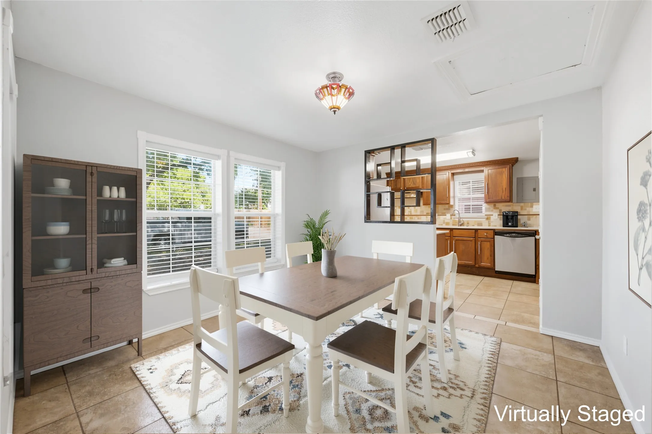 Virtually staged dining room with kitchen in the background