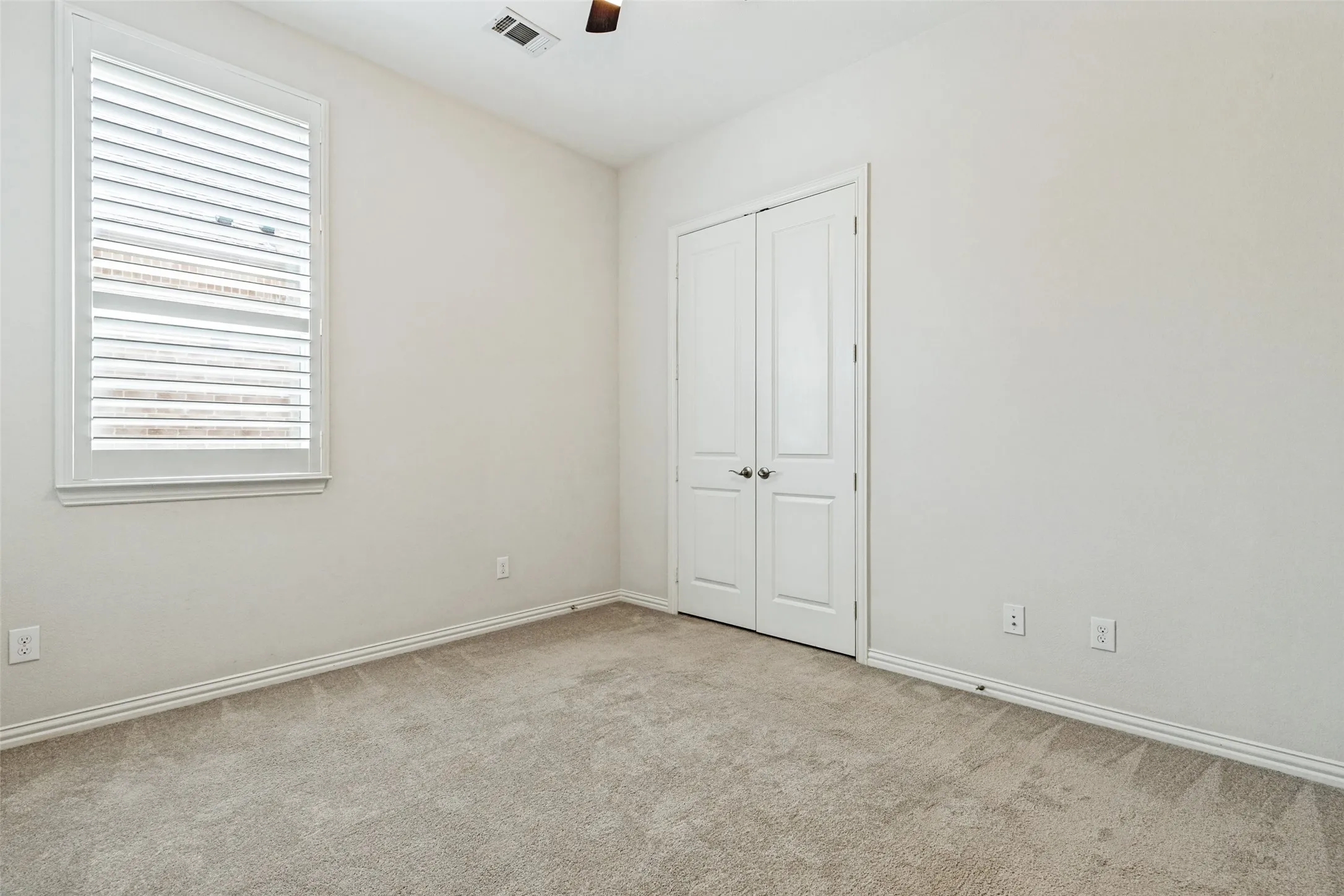 Neutral-toned carpeting enhancing the room's light-colored walls and white trim