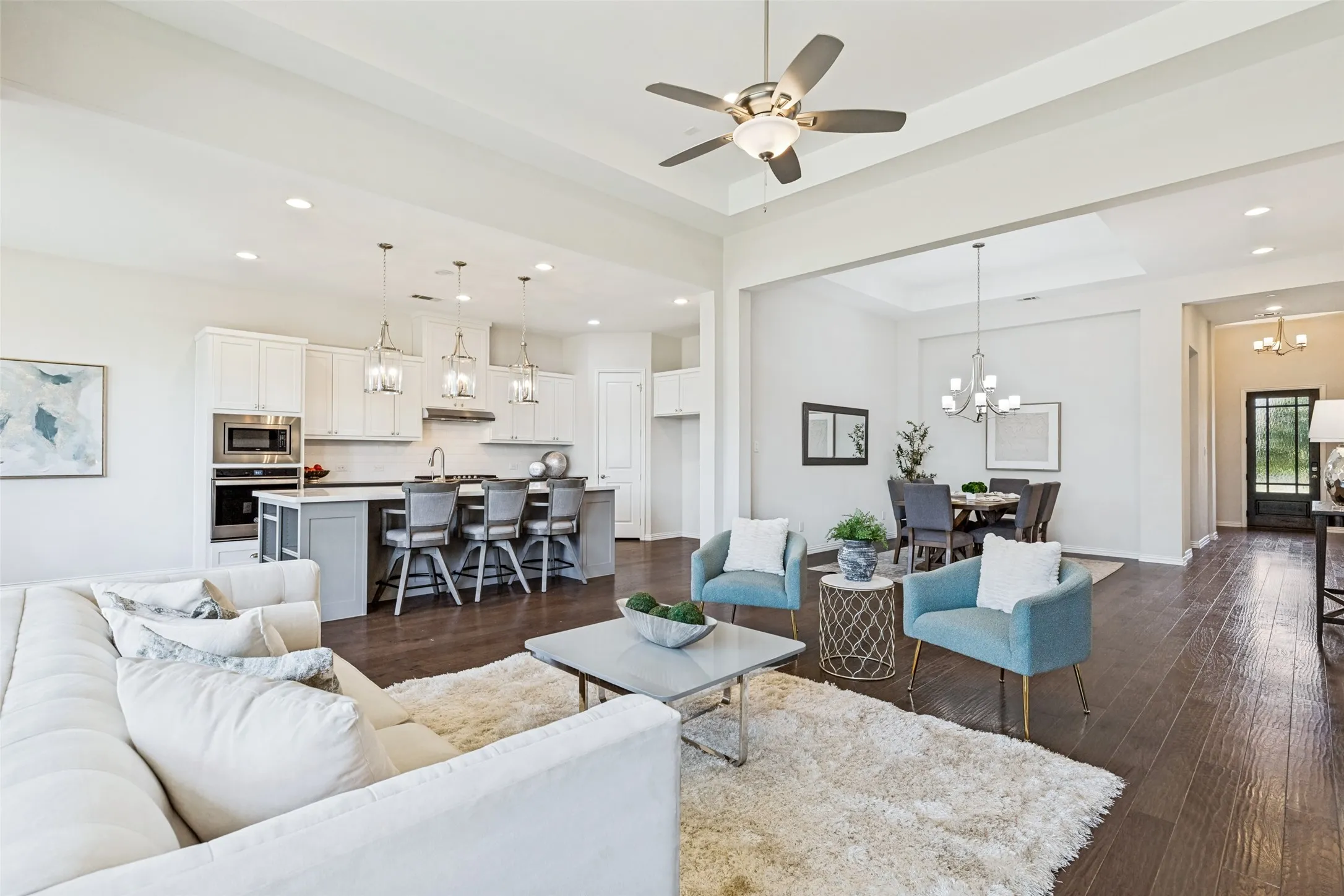 Open-concept living space featuring wood-finish flooring, recessed lighting, and a ceiling fan
