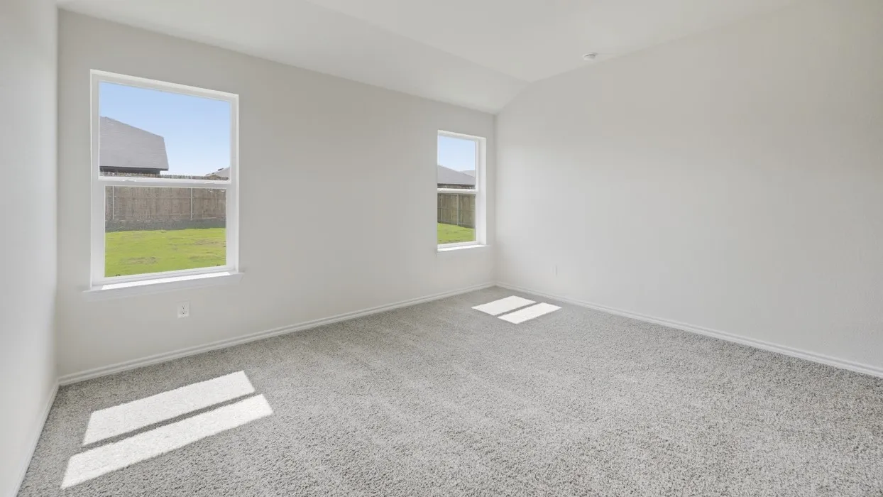 Spacious room featuring vaulted ceilings, light gray carpeting, two windows, and white baseboards