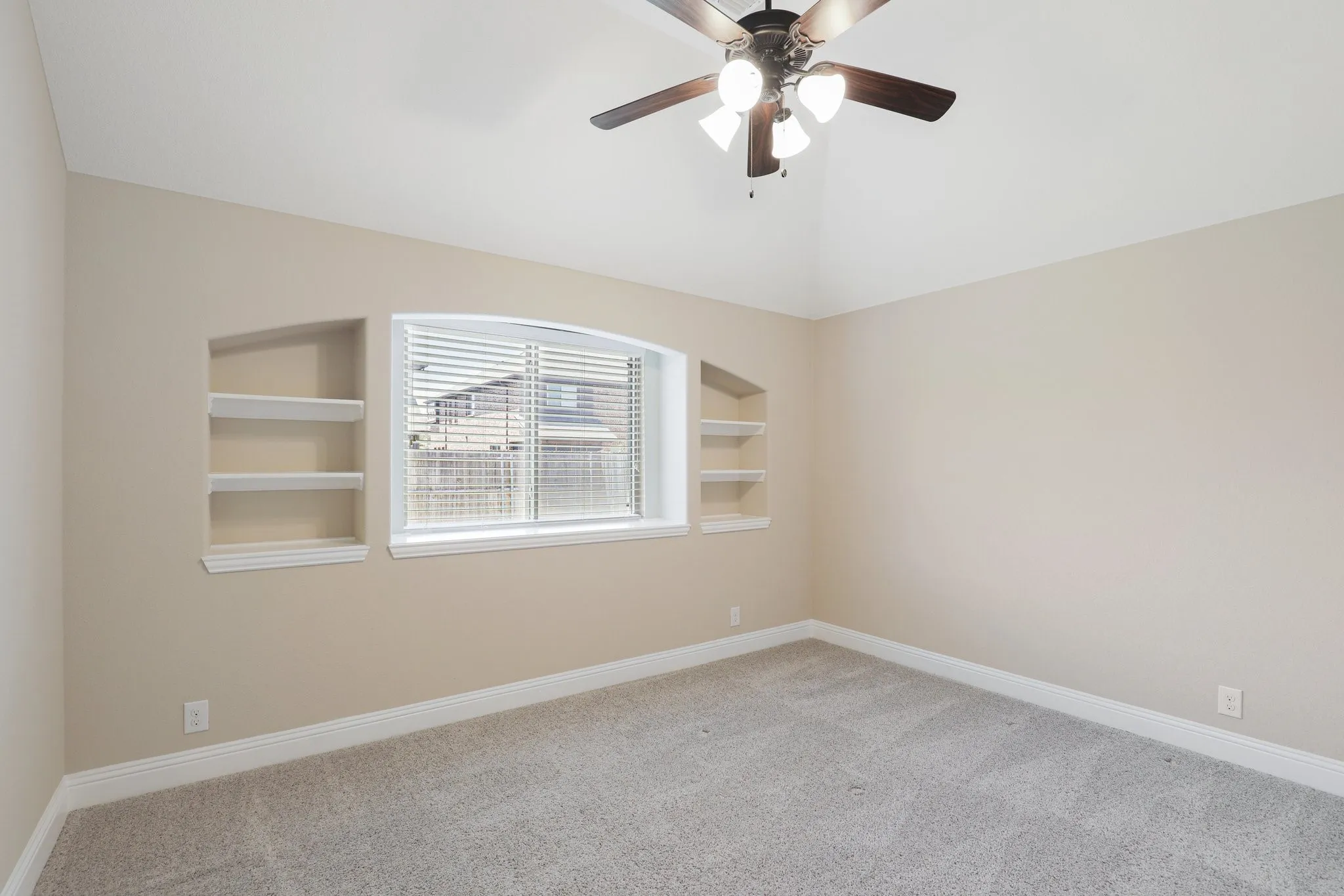 Carpeted room featuring a vaulted ceiling and a ceiling fan with integrated lighting