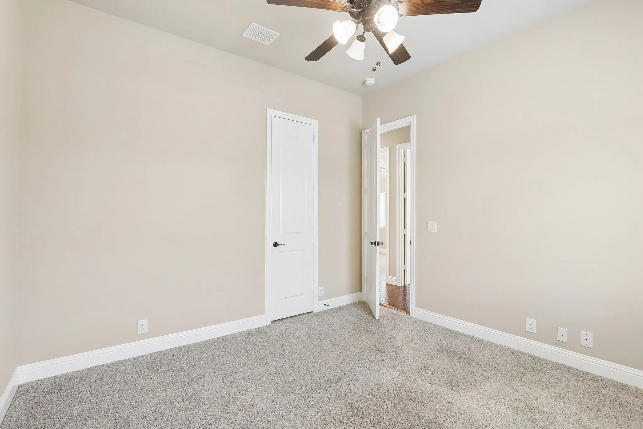 Bedroom featuring neutral wall paint, light gray carpet, white baseboards, and a ceiling fan with light fixture