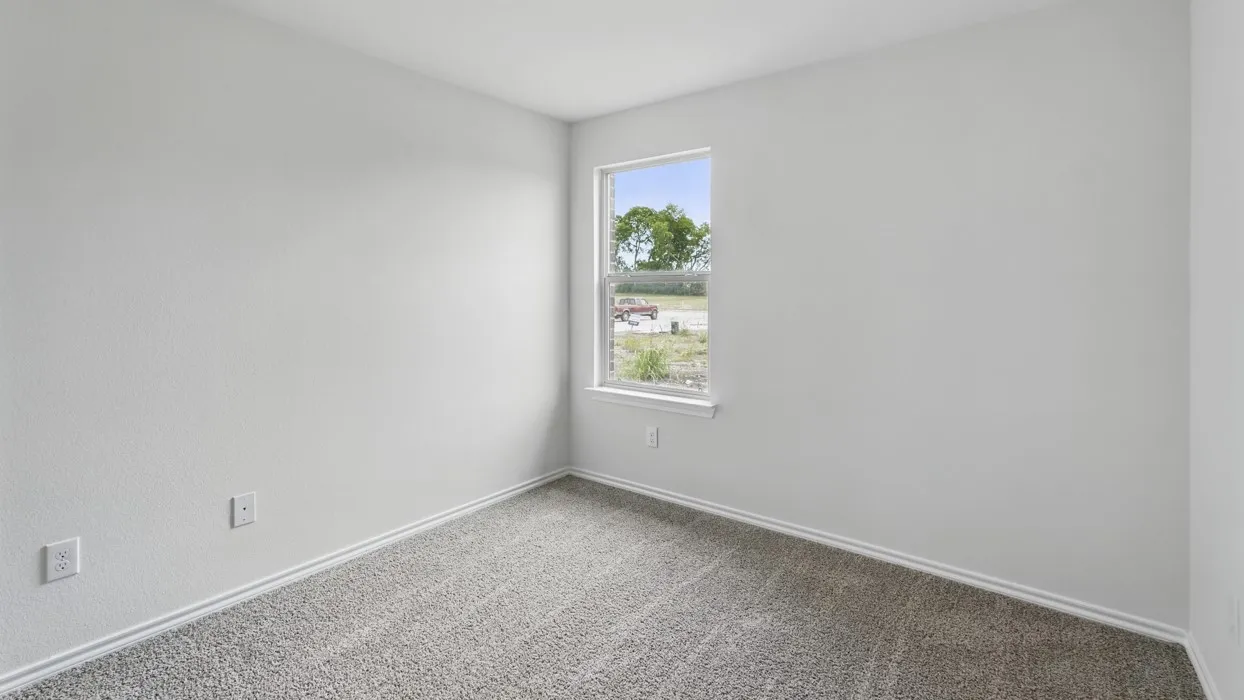 Neutral-toned room featuring a single window with white trim, light gray textured walls, and gray carpet flooring