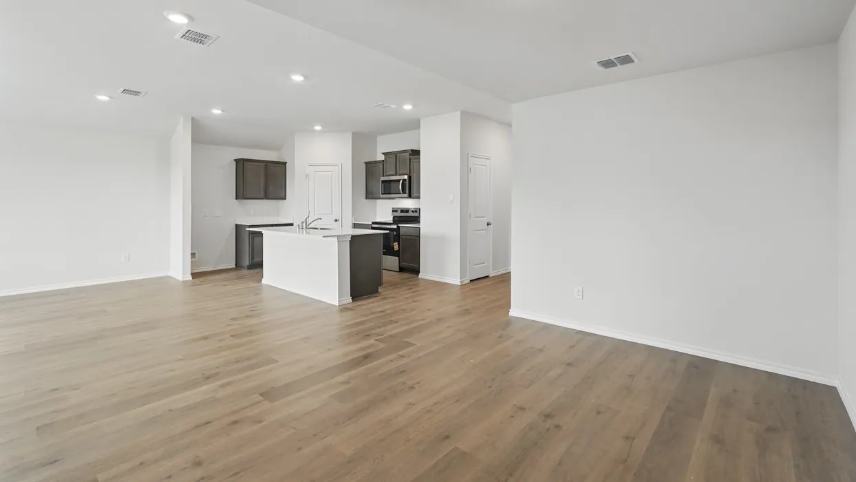 Open-concept living area featuring wood-finish flooring, recessed lighting, and a neutral color palette