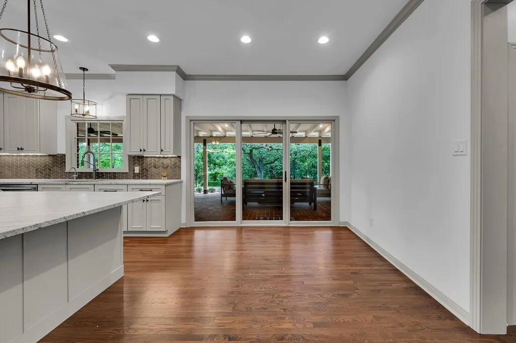 Kitchen area featuring a large center island with a light-toned countertop, gray shaker-style cabinetry, and a herringbone pattern tile backsplash