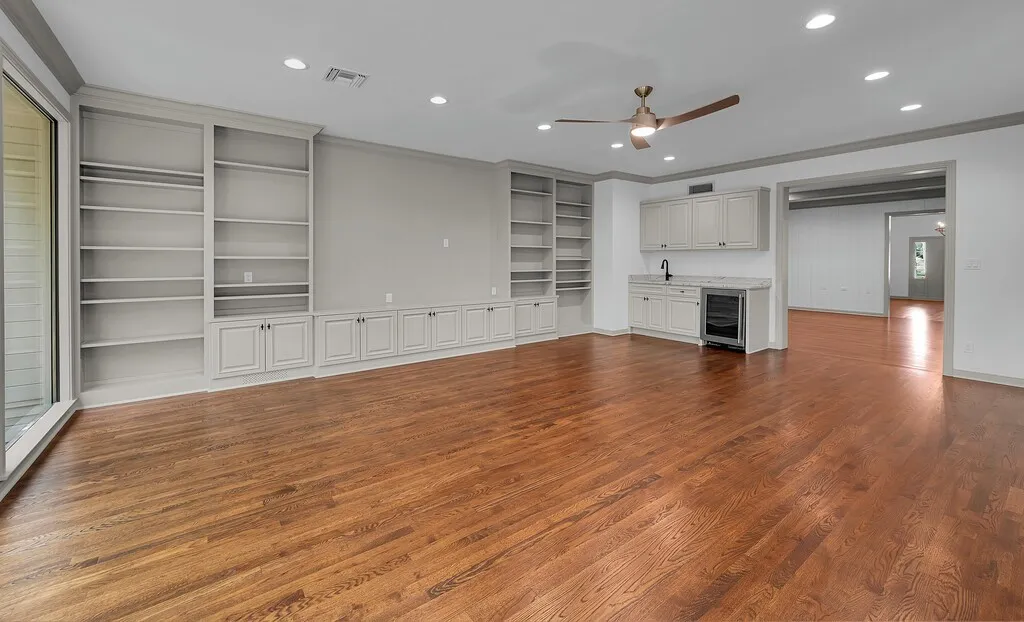 Spacious room featuring rich wood-finish flooring, recessed lighting, and a ceiling fan