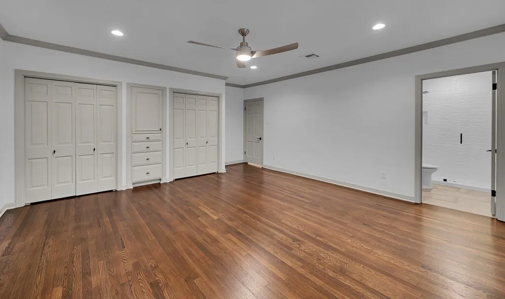Spacious room featuring rich wood-finish flooring and light-toned walls