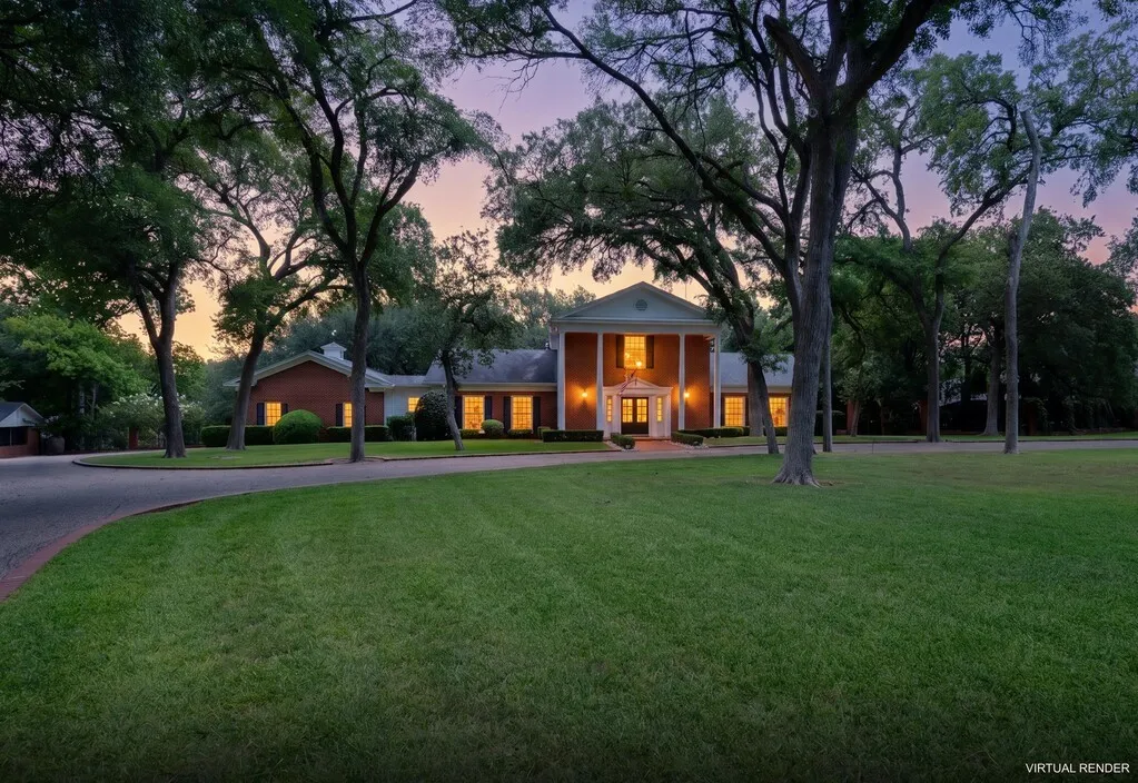 Brick exterior with a grand portico featuring white columns, a meticulously maintained lawn, mature trees, and a curved paved driveway