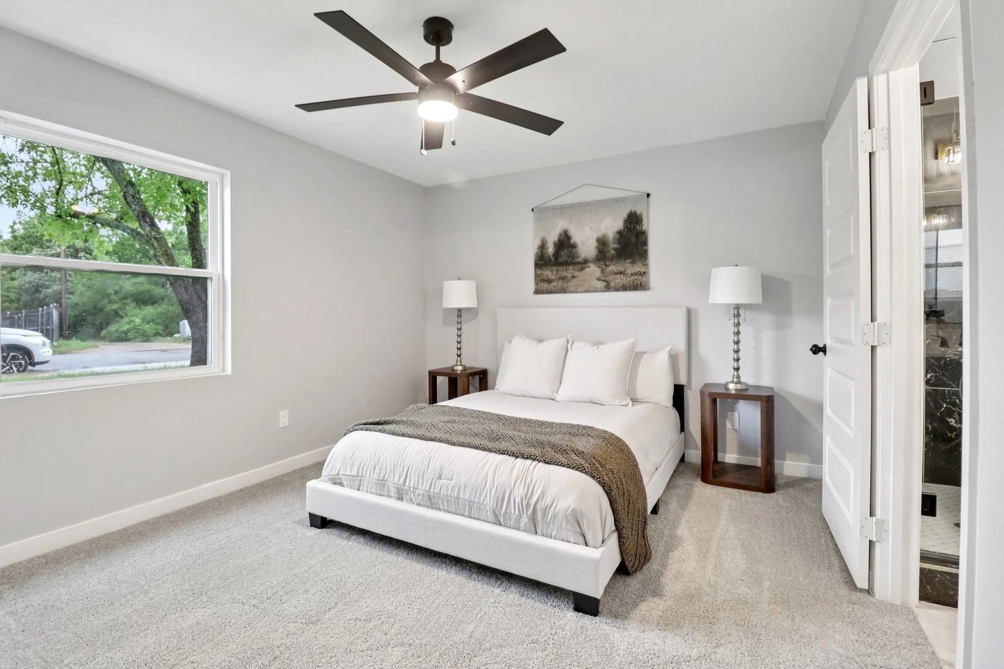 Carpeted bedroom with a ceiling fan, a window, and a white paneled door