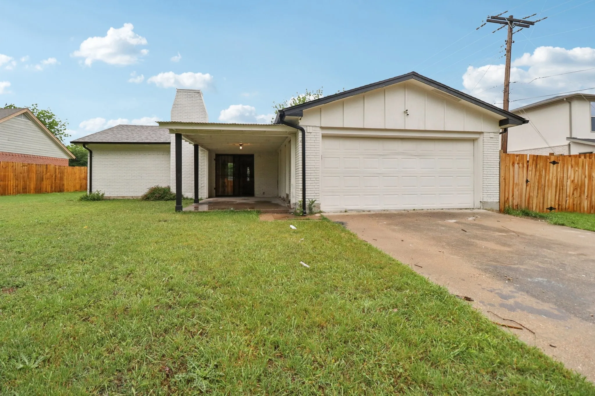 White brick exterior with a front-facing garage and an attached covered entryway