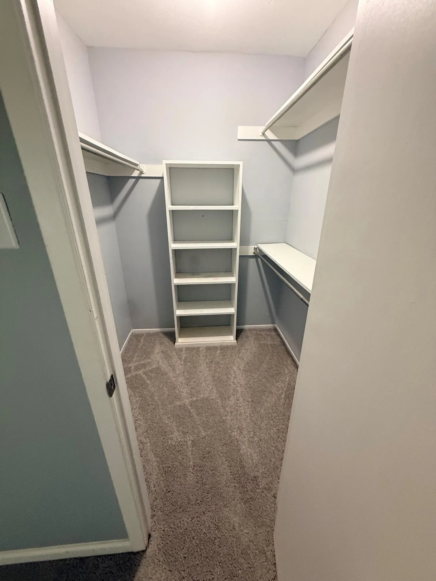 Walk-in closet featuring light gray wall paint, gray patterned carpet, and recessed lighting