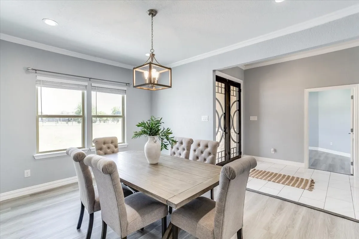 Dining area featuring light wood-finish flooring and a contemporary caged chandelier