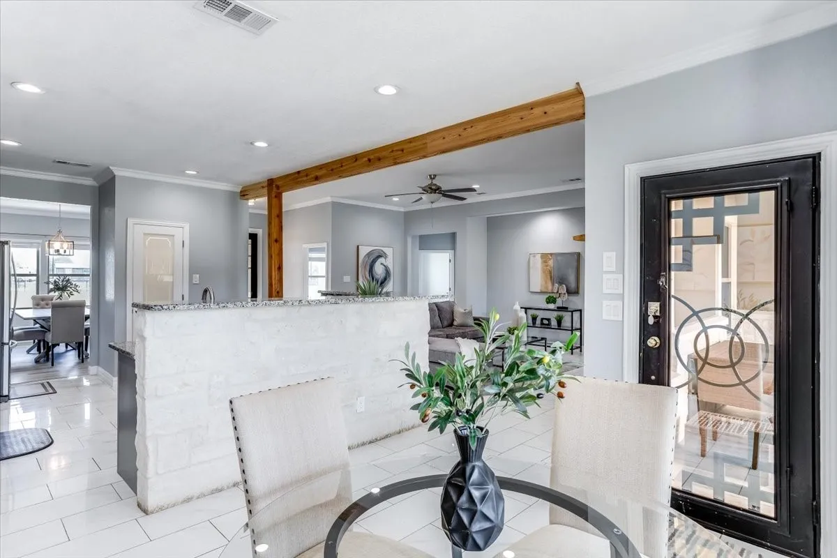 Entryway featuring a decorative glass-paneled door, tile flooring, and crown molding