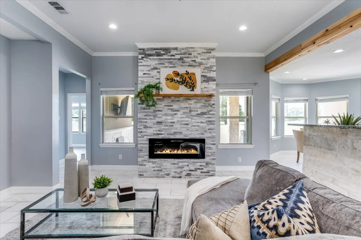 Textured stone-tile fireplace surround featuring an electric insert and a wood mantel