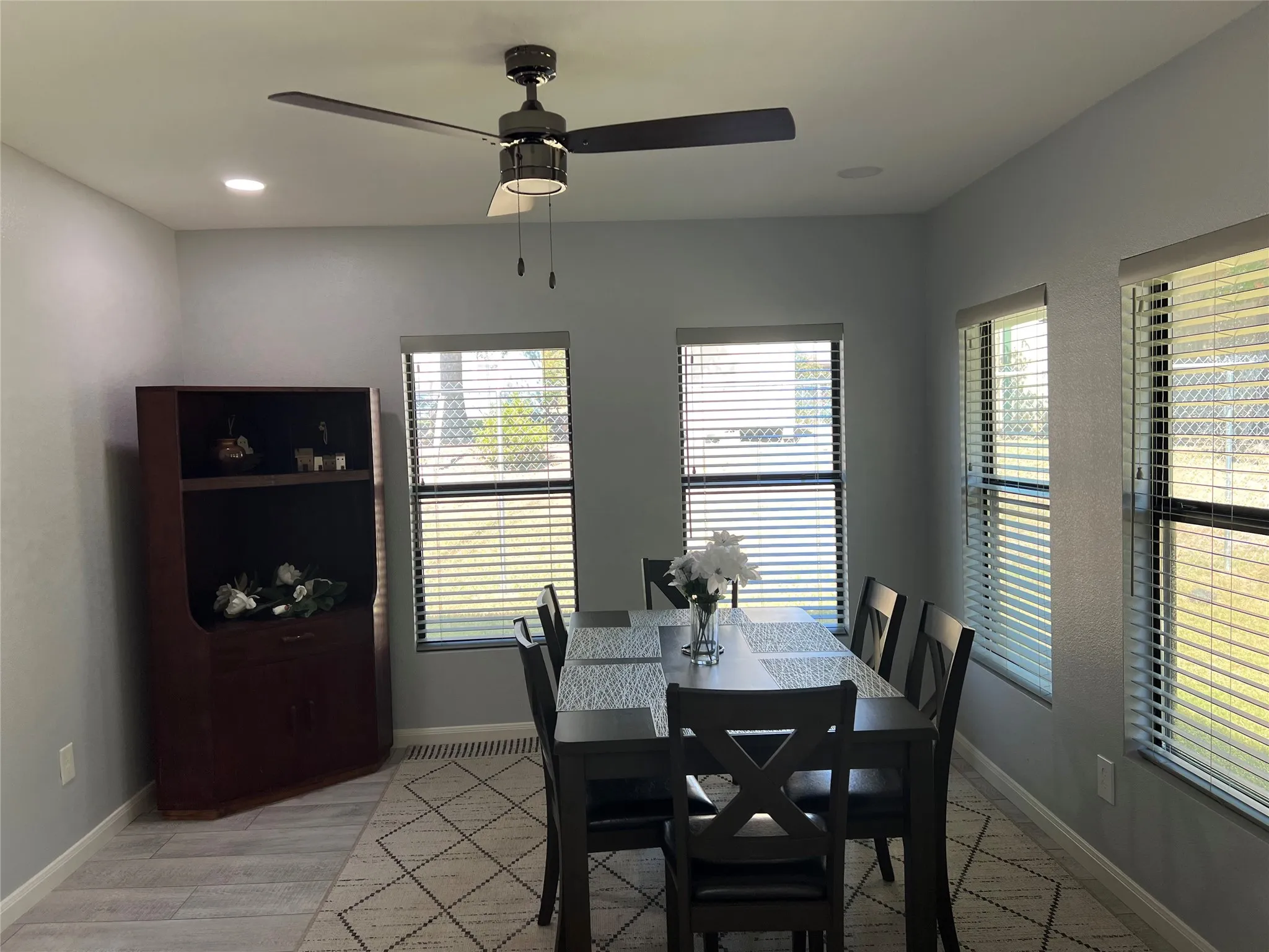 Dining area featuring light gray walls and wood-finish tile flooring