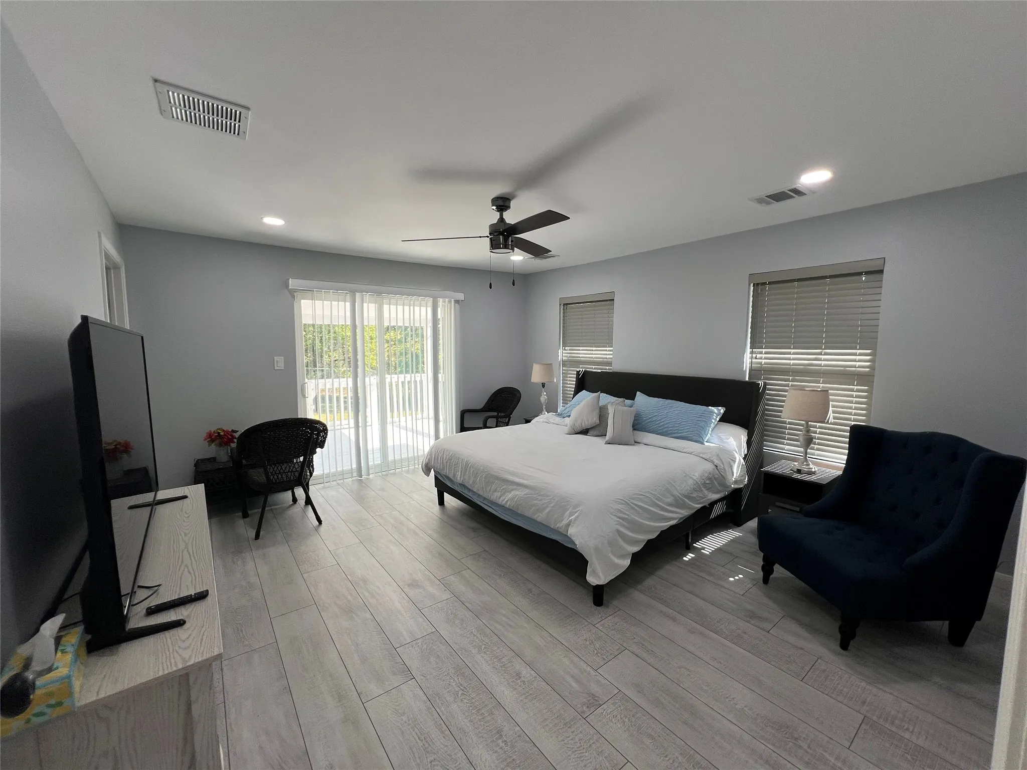 Spacious room featuring wood-finish flooring, recessed lighting, and a ceiling fan