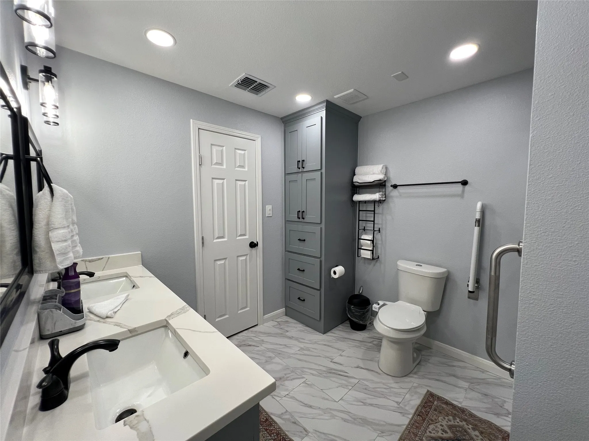 Bathroom featuring a double vanity with stone countertops, gray cabinetry, large format marble-look tile flooring, and recessed lighting