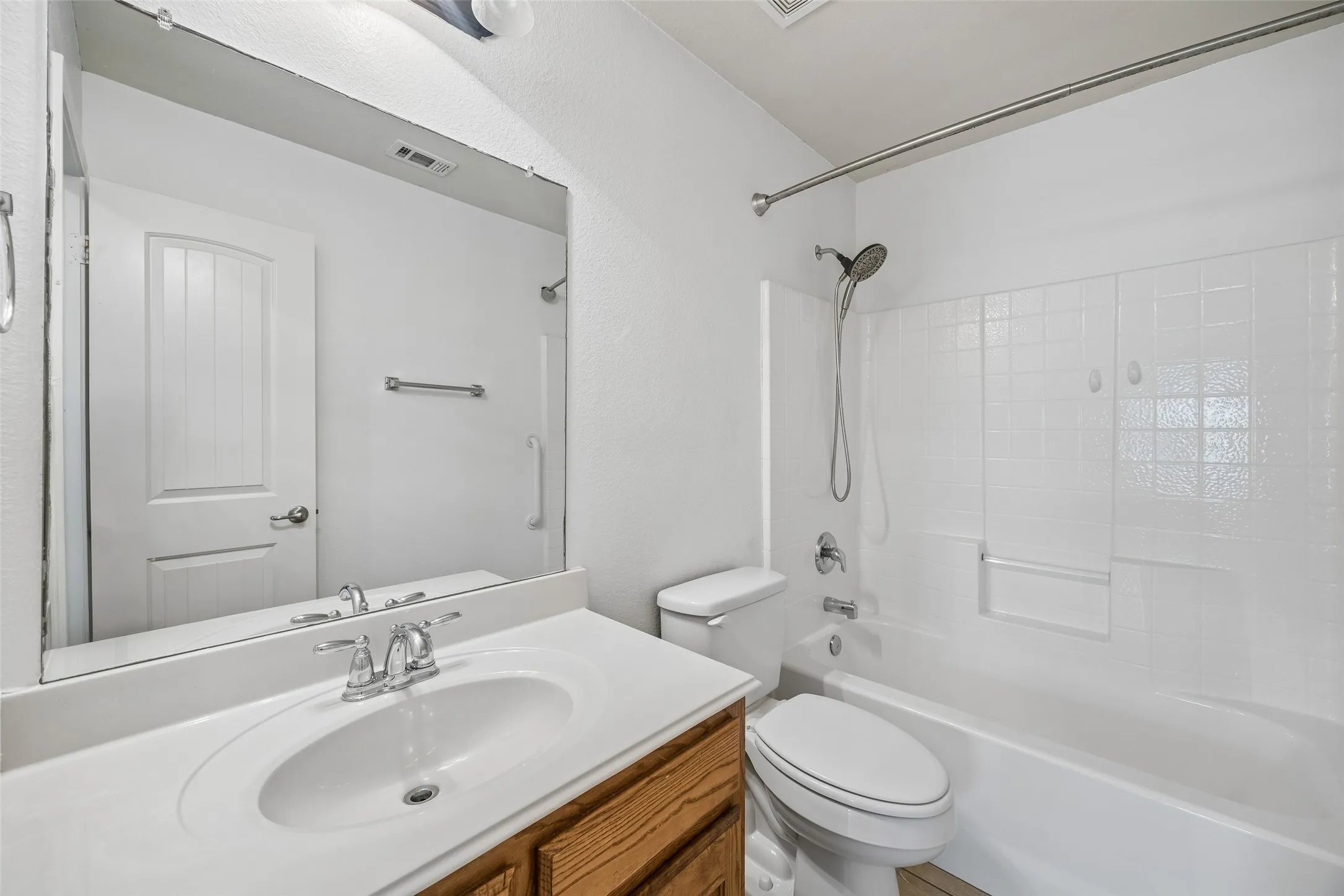 The secondary bathroom features a comfort-height toilet, grab bars, a spacious vanity, and a tub/shower combination for added convenience.