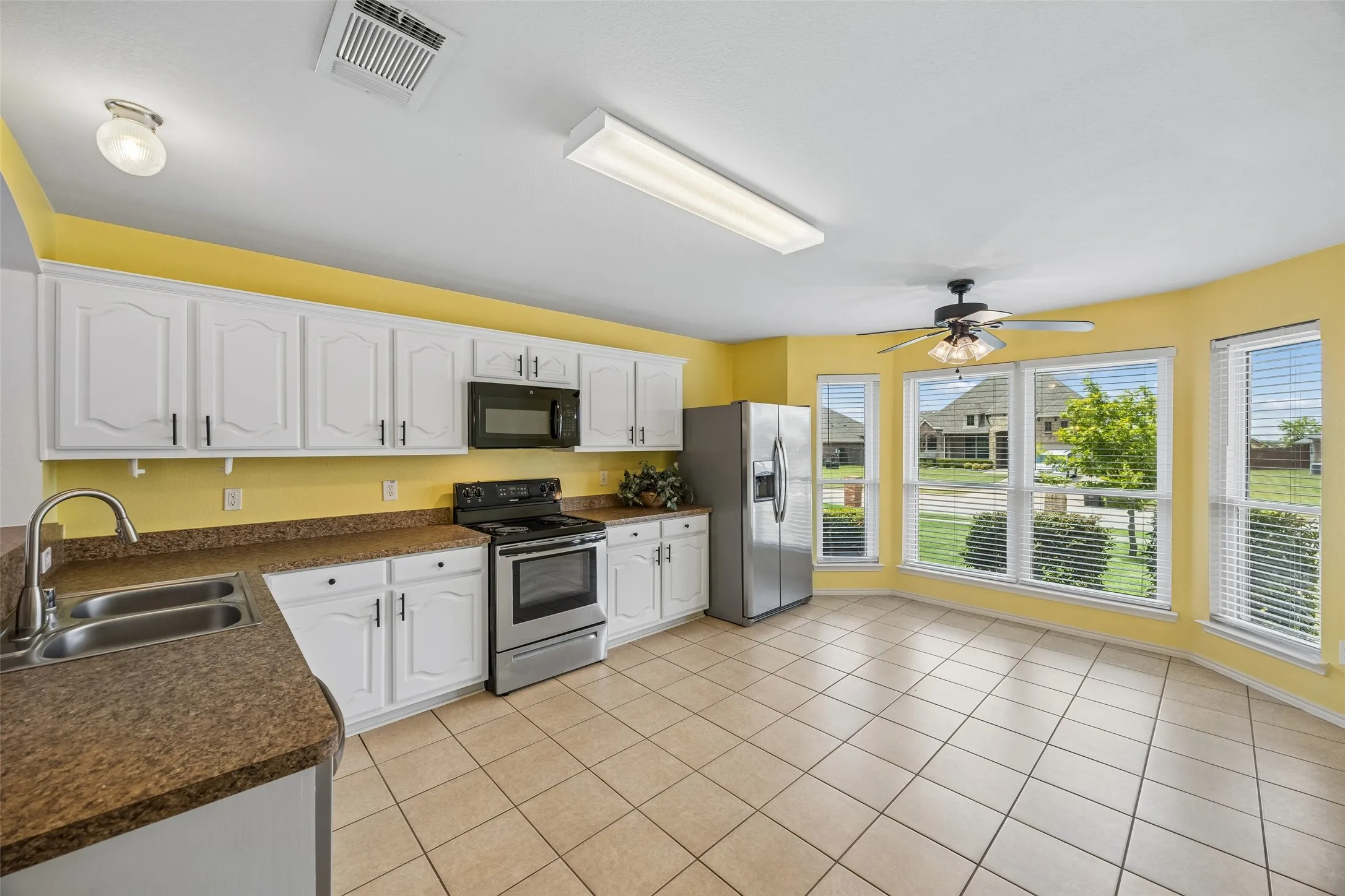Designed for everyday living, this spacious kitchen offers abundant cabinetry, generous counter space, stainless steel appliances, and a bright breakfast nook perfect for morning coffee or casual meals.
