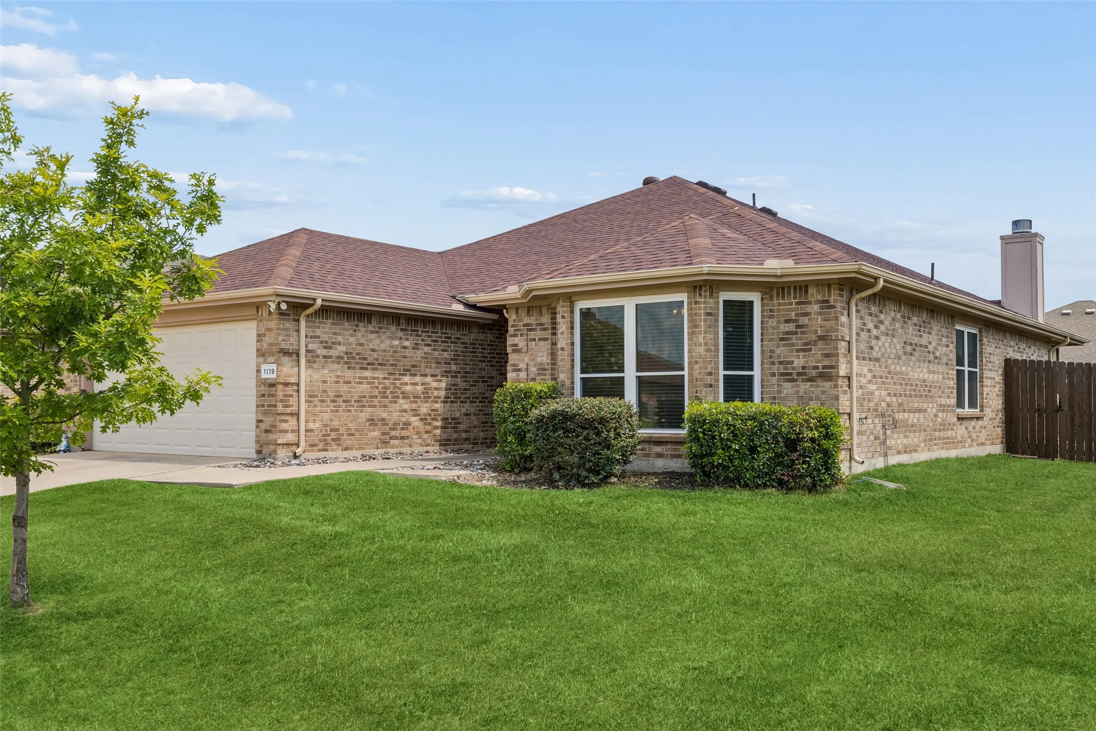 Beautiful corner perspective showcases the home's timeless brick exterior, mature landscaping, and pride of ownership.