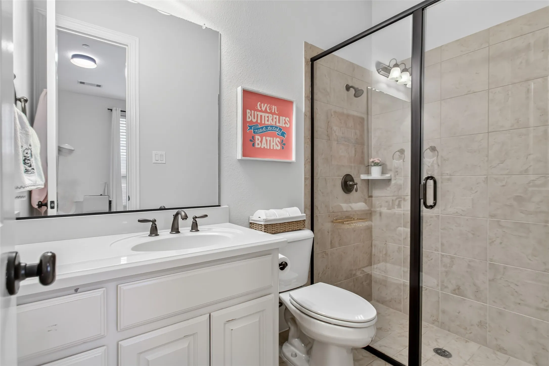 Bathroom featuring a single vanity with an integrated sink, dark bronze faucet, and a large frameless mirror
