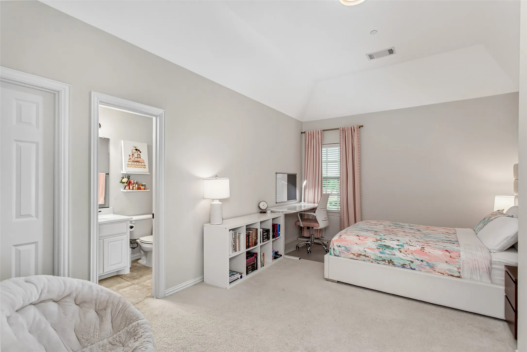 Carpeted interior space featuring a vaulted ceiling and a rectangular window with blinds
