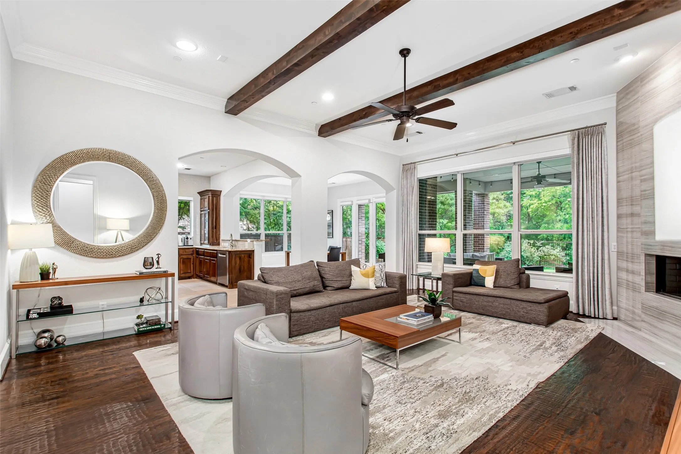 Spacious interior featuring dark wood-finish flooring, exposed ceiling beams, and arched doorways
