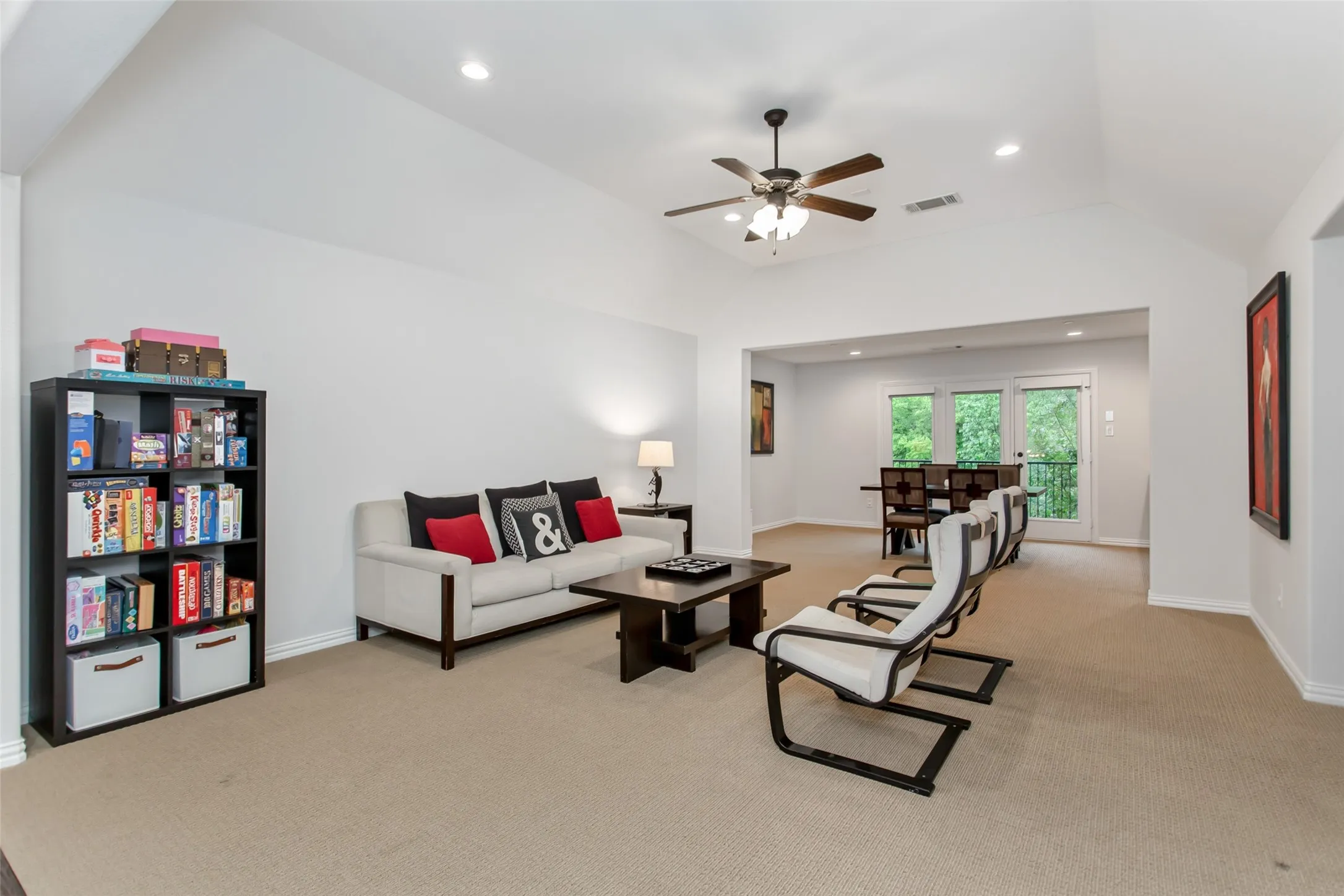 Spacious living area featuring vaulted ceilings, recessed lighting, and a ceiling fan