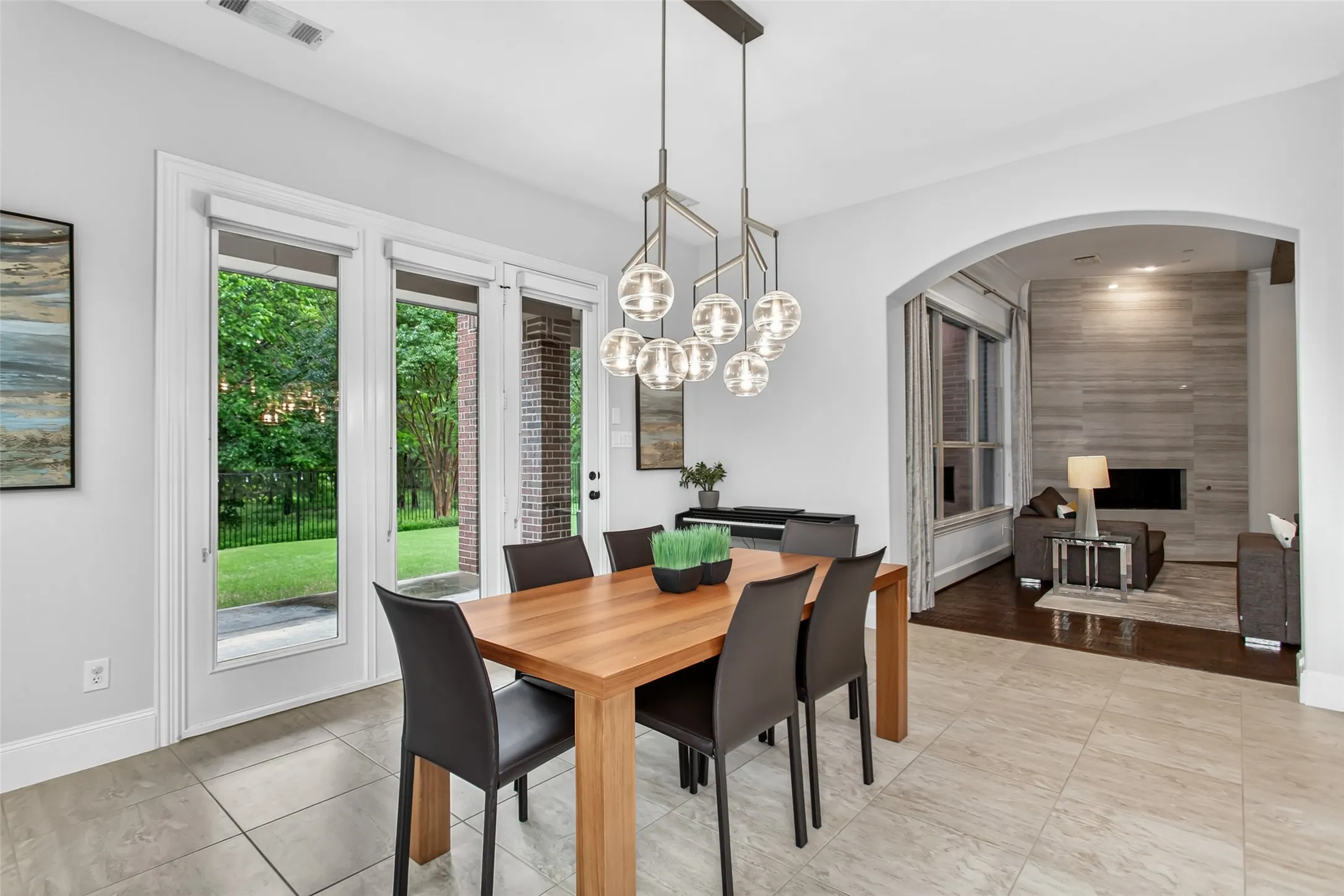 Dining area featuring tile flooring, a contemporary chandelier, and French patio doors leading to a green yard