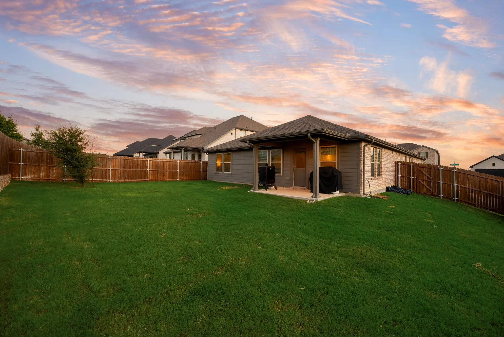 Expansive backyard featuring a manicured lawn and wood fencing