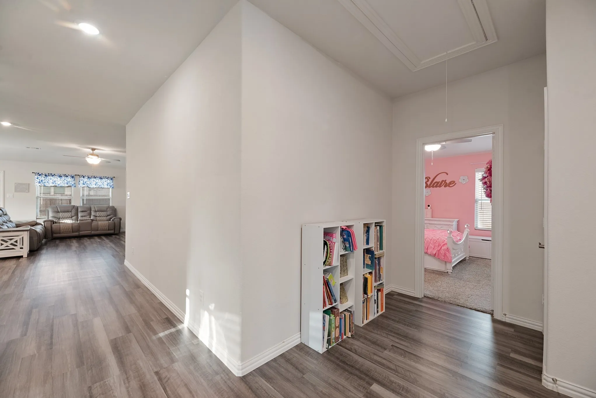 Hallway featuring wood-finish flooring, recessed lighting, and a built-in shelving unit