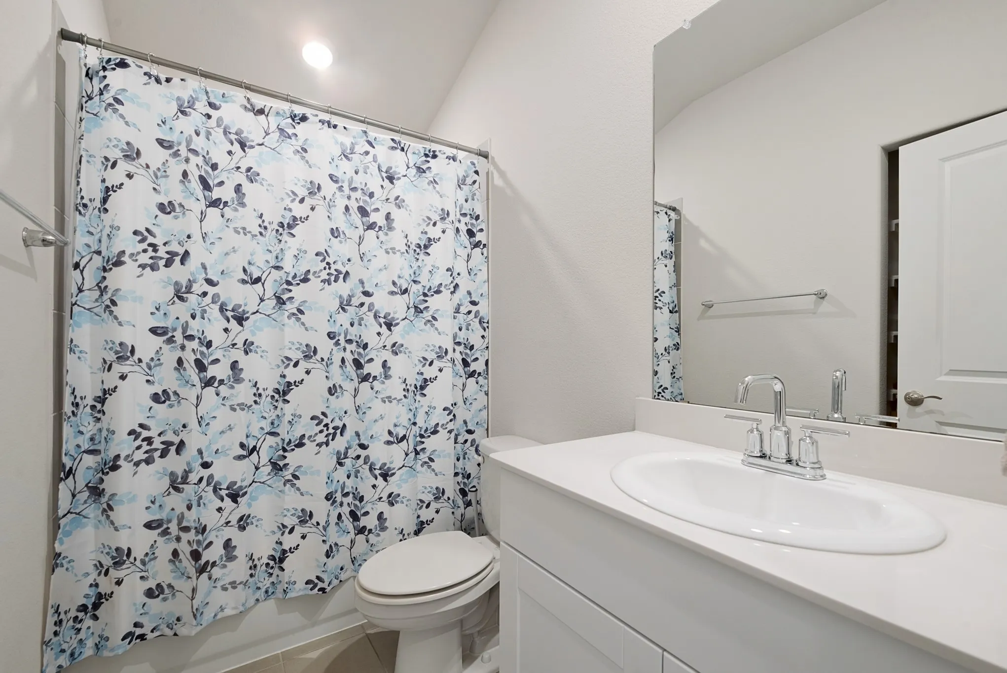 Bathroom featuring a white vanity with an undermount sink, a chrome faucet, and a large wall-mounted mirror