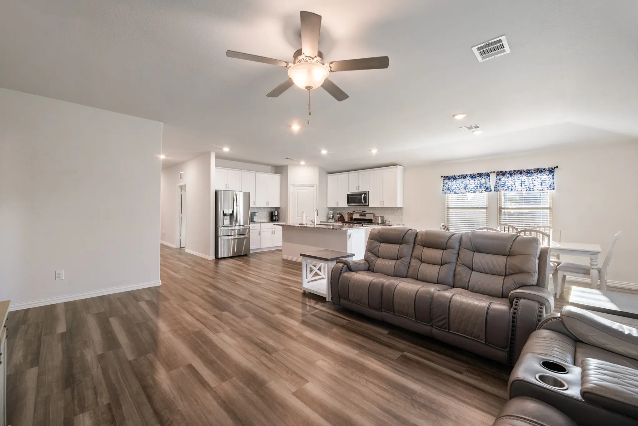 Open-concept living space featuring wood-finish flooring, recessed lighting, and a ceiling fan