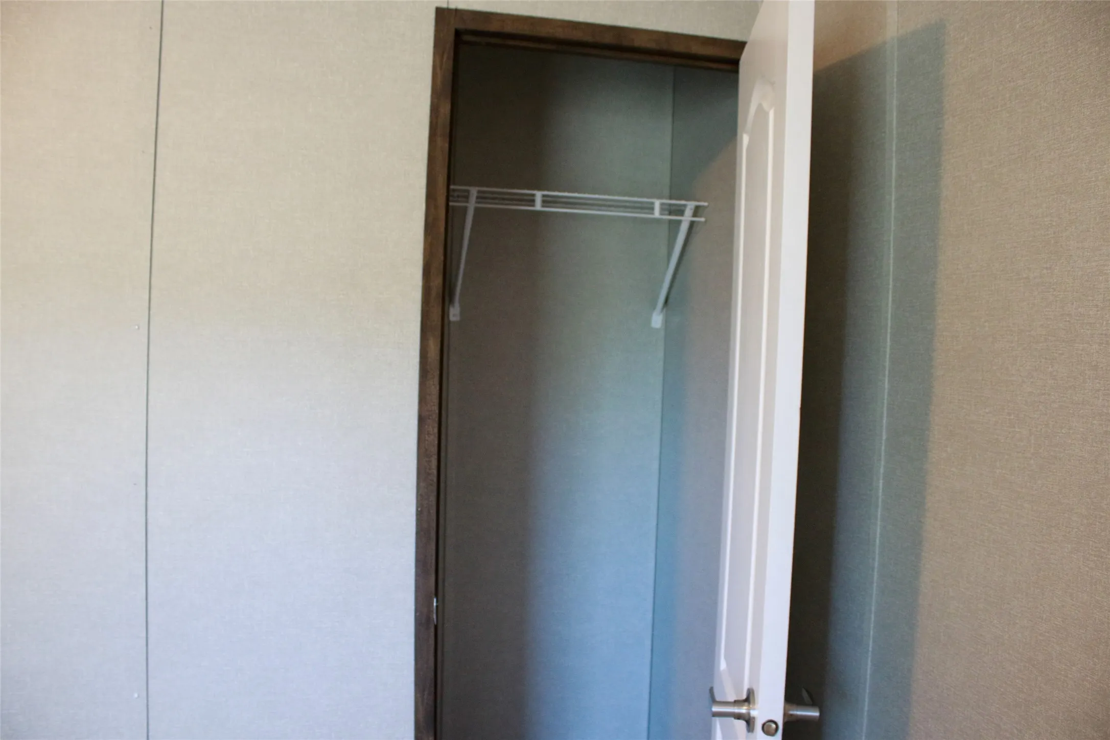 White interior door with paneling, metal wire shelving