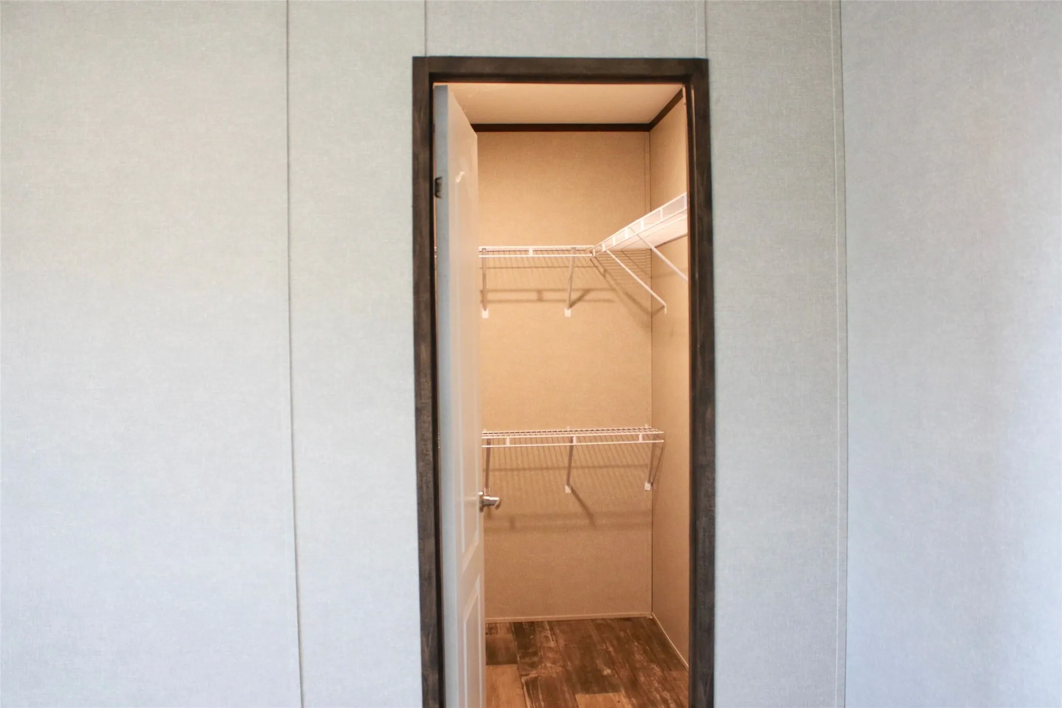 Closet with wire shelving and wood-finish flooring