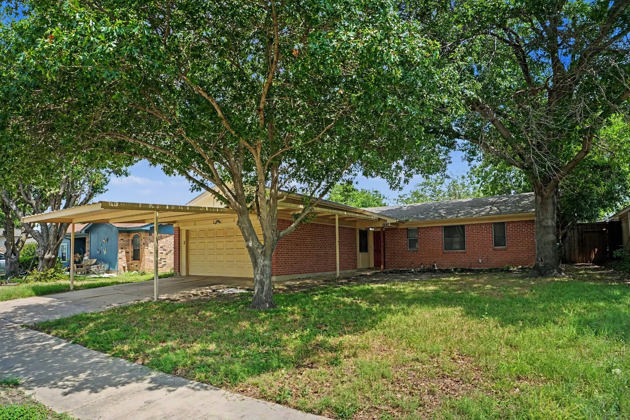 Covered double wide carport and covered sidewalk going into the front door.