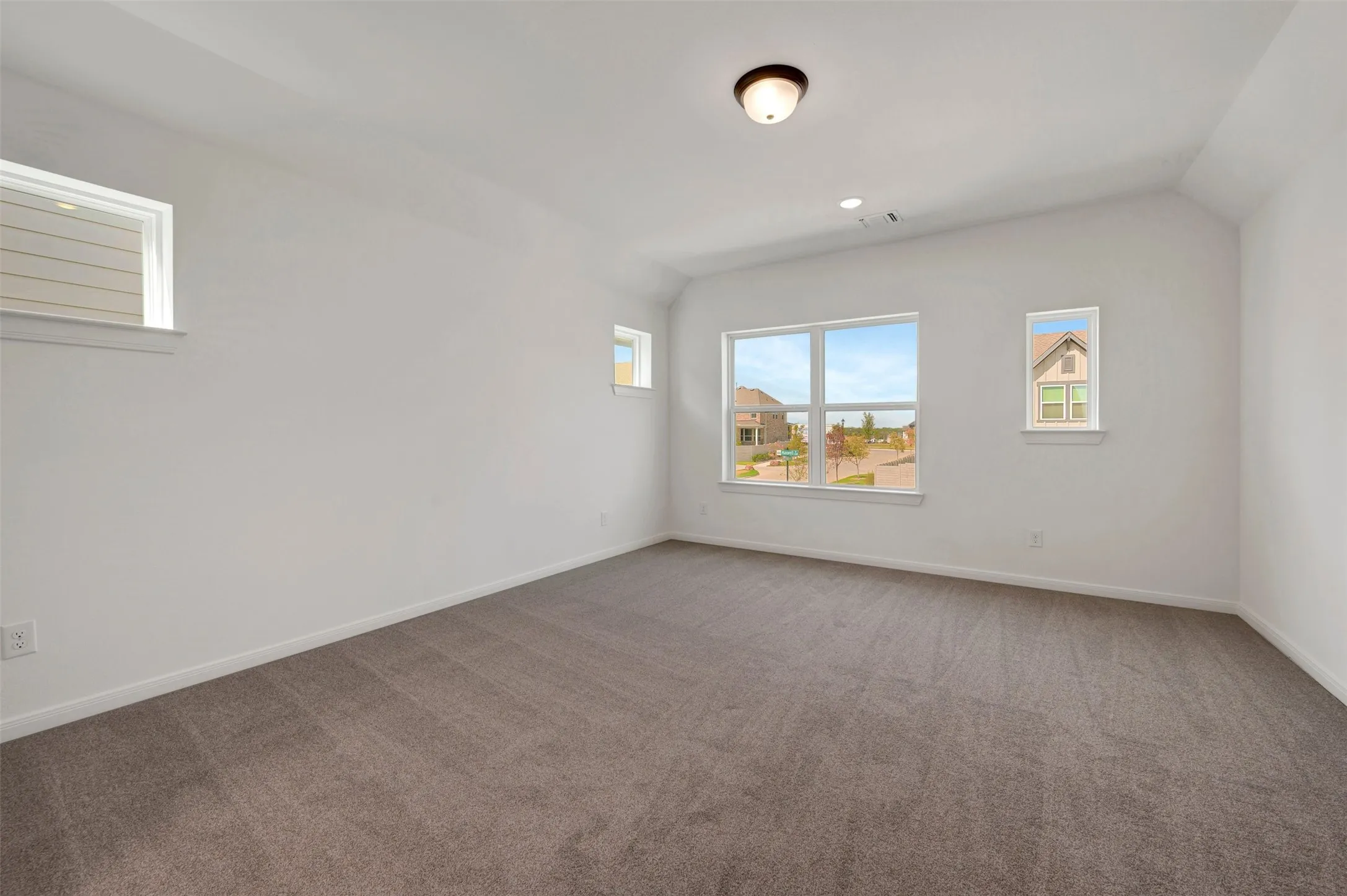 Carpeted flooring, multiple windows, recessed lighting, and a semi-flush mount light fixture