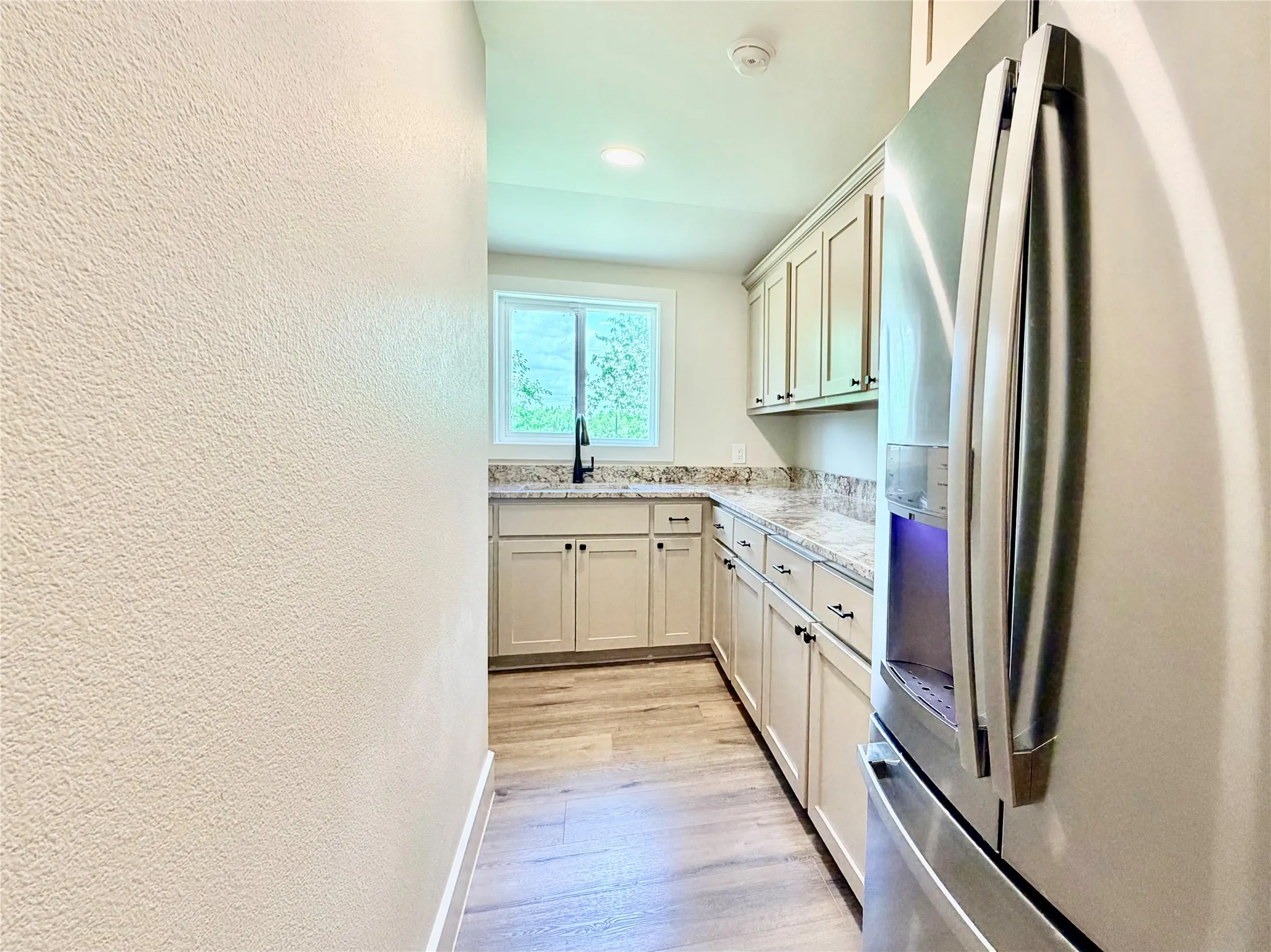 Step into a beautifully updated kitchen boasting high-end, full-sized stainless steel appliances and sleek, modern cabinetry.