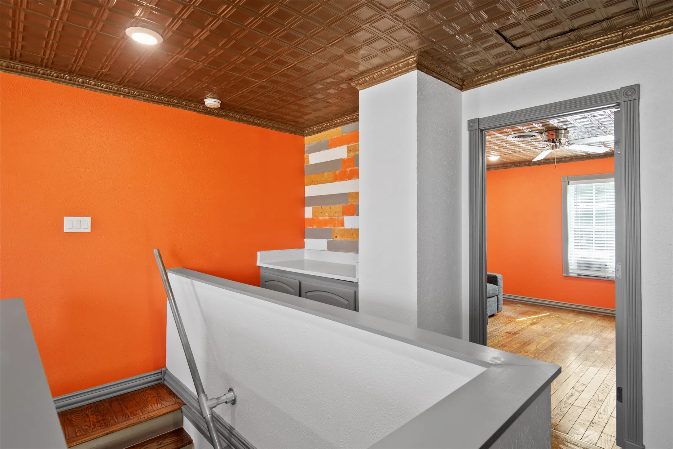 View of stairwell with industrial bar, and storage cabinet.