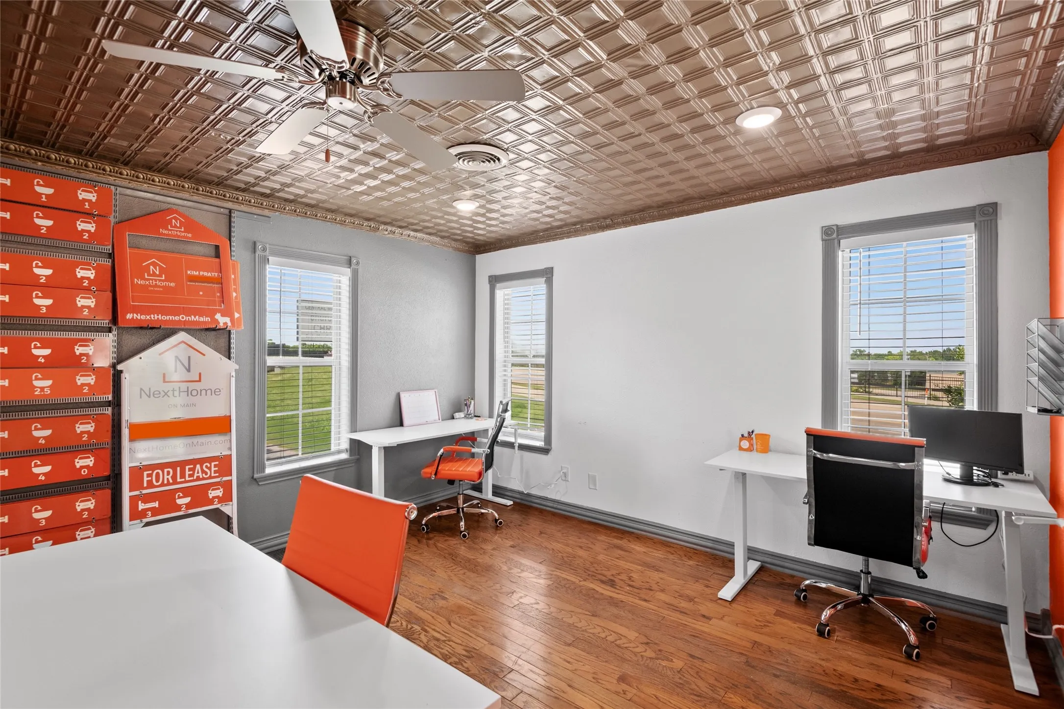 Room featuring a decorative pressed tin ceiling, wood-finish flooring, two windows with blinds, recessed lighting, and a ceiling fan