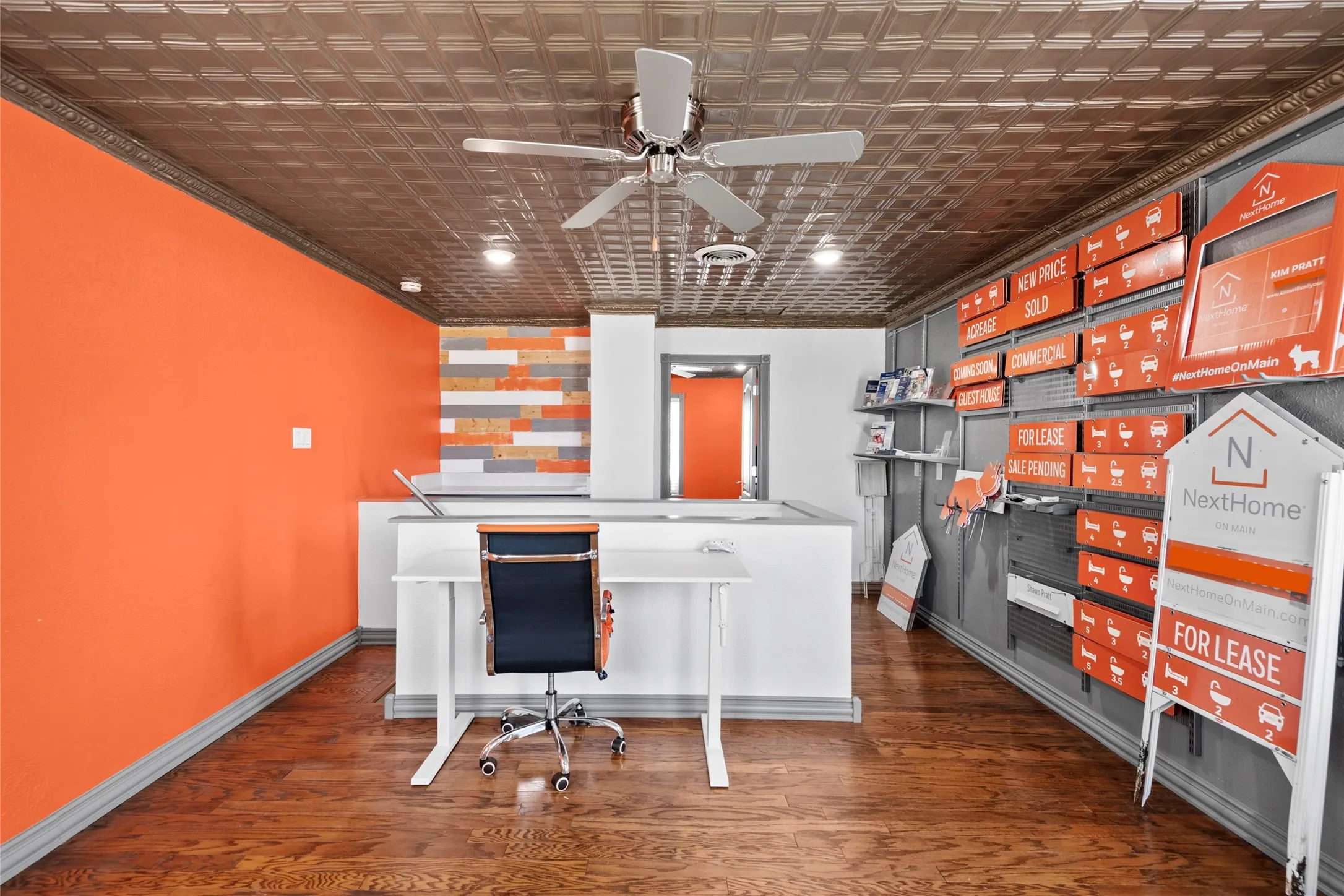 Interior space featuring wood-finish flooring, a patterned ceiling, and a ceiling fan