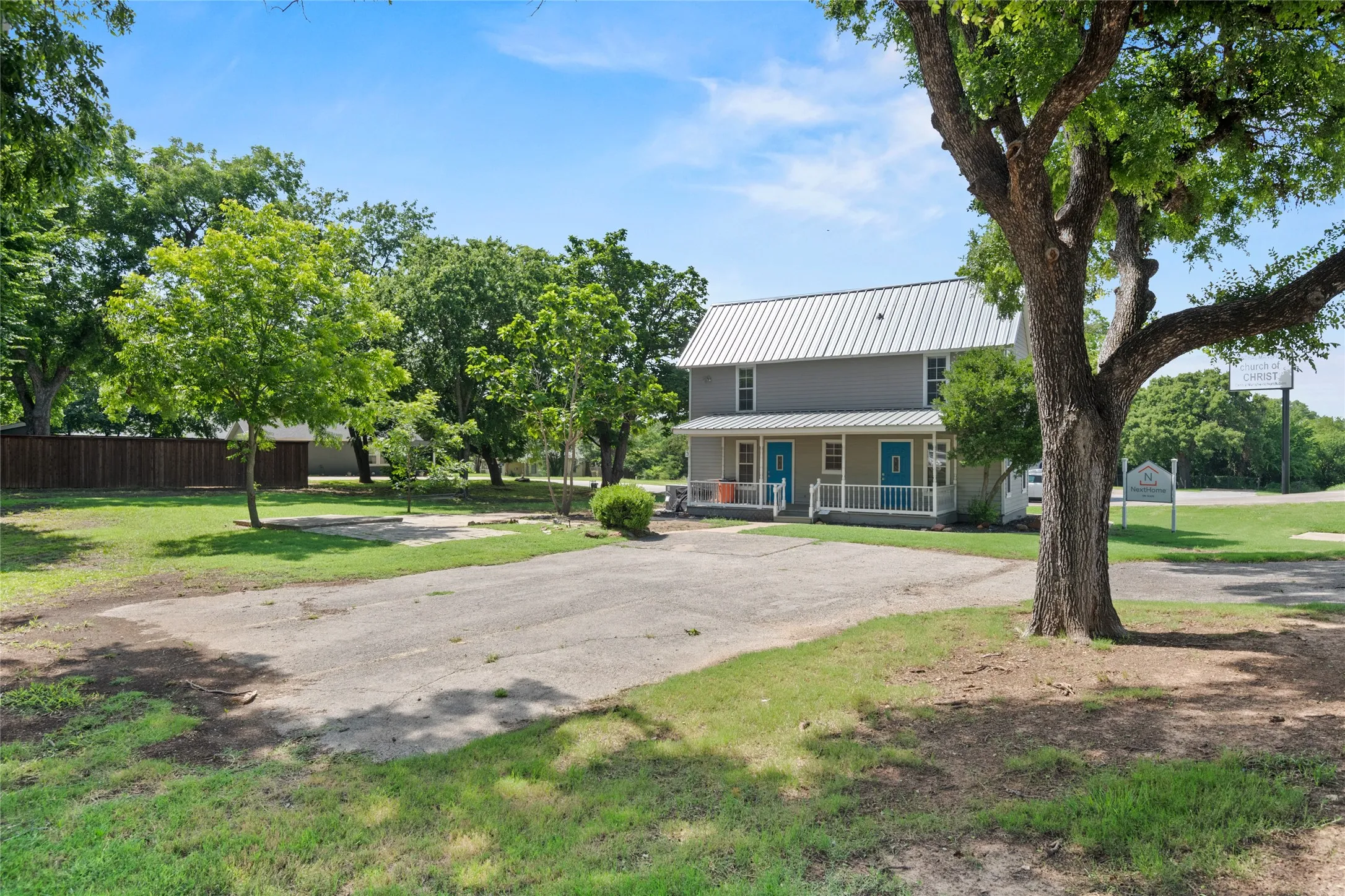The property features large trees, two separate entries on this side.