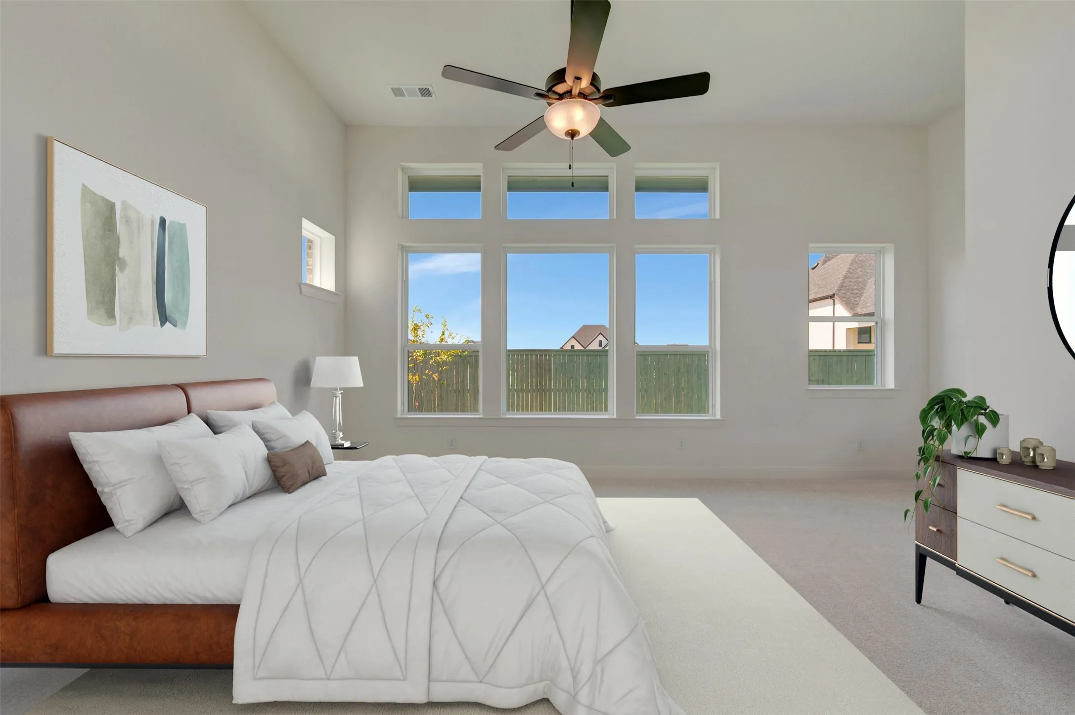 Vaulted ceilings with a ceiling fan, multiple large windows, and carpeted flooring