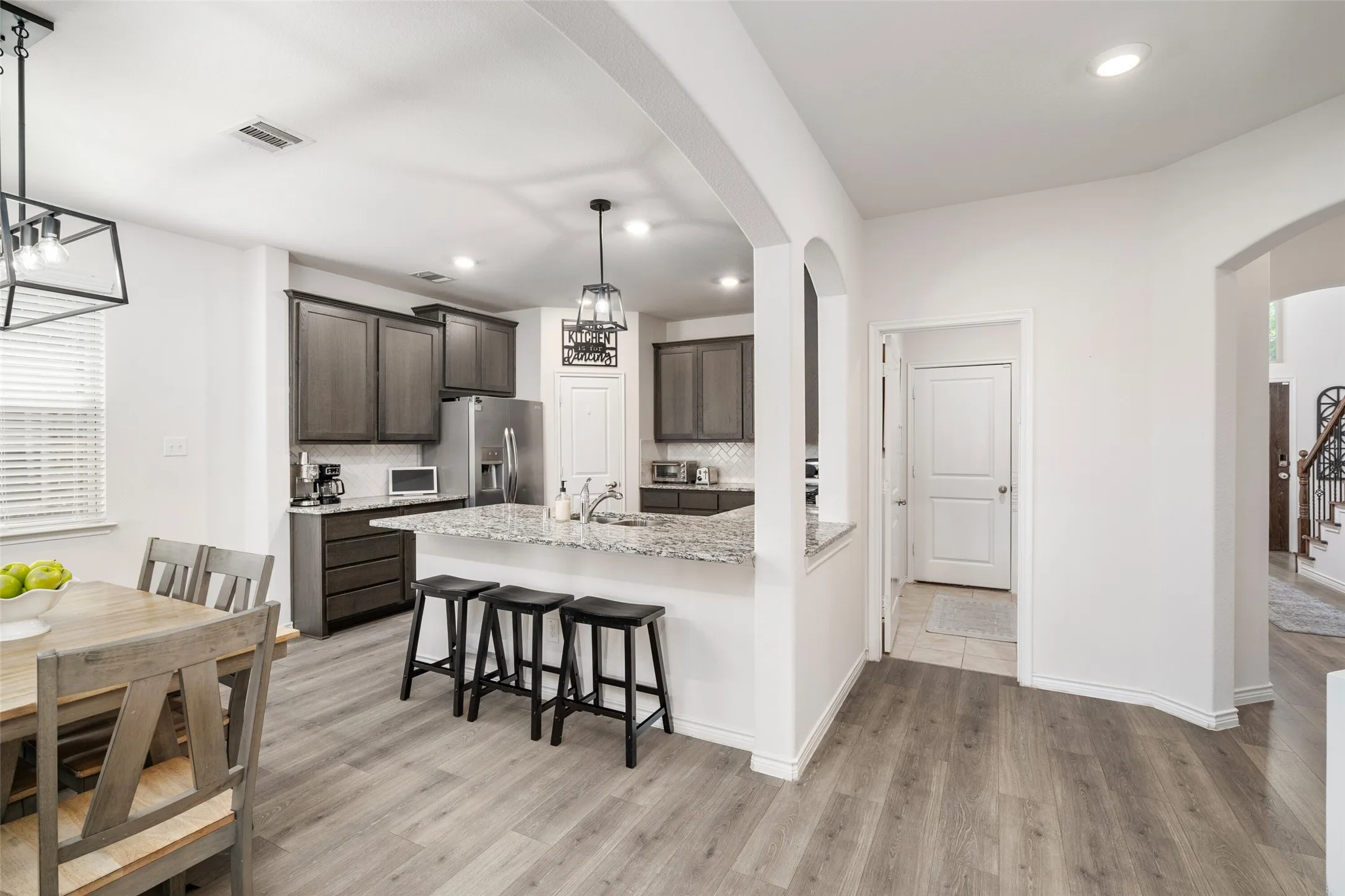 Open Floorplan with view from Dining area toward Kitchen featuring granite counters.